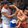 A Yanomami nurse vaccinates a mother.