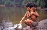 Bien temprano en la mañana una madre recoge agua para la familia.